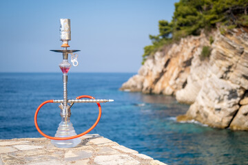 Hookah on the background of the blue sea and rocks.