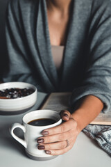Close-up of a woman's hand holding a cup of hot coffee. fashion, leisure