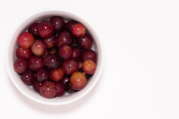 Grapes in a bowl. Top view on a white background.