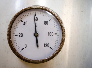Old rusty pressure gauge to measure temperature of an aluminum tank.