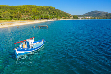 Fototapeta na wymiar Panorama of Mediterranean sea coastline, Greece, Halkidiki, Sithonia. Top view of sail boat in blue water, white sand beach, pine forest background