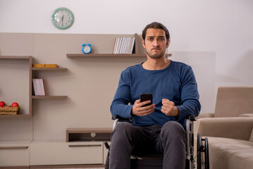 Fototapeta premium Young man in wheel-chair suffering at home