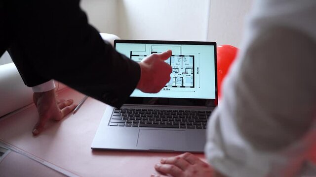 close up of man contactor and entrepreneur using laptop. Businessman and man architect browsing drafts on laptop while working on project in workplace together