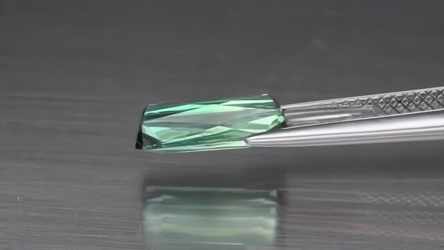 natural green indicolite tourmaline on the grey background