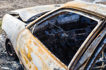 Burned down car, abstract background, selective focus. The situation of protests in the world.