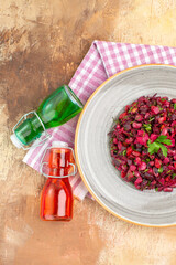 top view salad on gray plate and red bottle