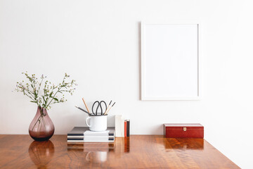 Stylish home office interior with photo frame mock up and bunch of flowers in vase.