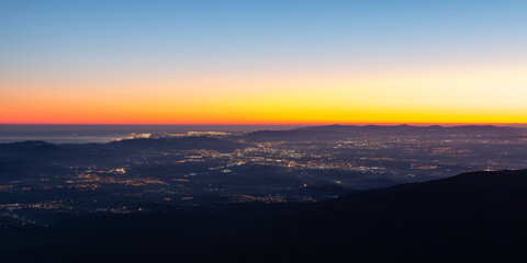 Aerial view of the city of Barcelona with city lights at sunset or sunrise. View of Barcelona, Mediterranean Sea, Catalunya-Catalonia, Spain. Panoramic view from Montseny, Turo de l'home.