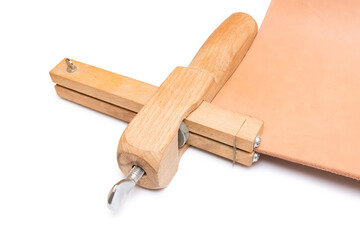 A tool for cutting belts and a piece of genuine leather.
