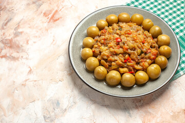 bottom view roasted eggplant salad and pickled plums on plate on turquoise white checkered tablecloth on nude background copy space
