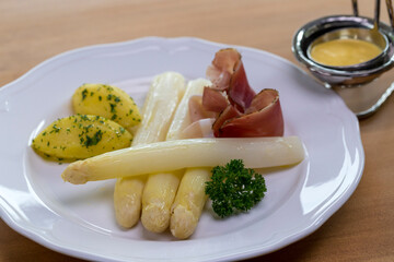 White German asparagus served with Black Forest ham, parsley potatoes and sauce Hollandaise