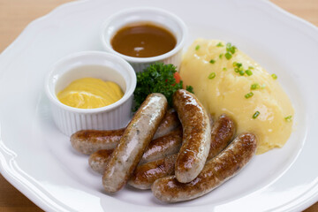 Six Bavarian grilled Nuremberg sausages served with potato mash, dark beer jus and mustard