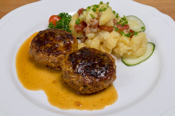 Pan-fried meatballs served with Bavarian potato cucumber salad