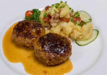 Pan-fried meatballs served with Bavarian potato cucumber salad