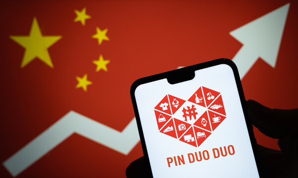 Stone / United Kingdom - January 15 2020: PinDuoDuo company logo on the smartphone and flag of China with growing arrow on the blurred background. Conceptual. Real photo, not a montage.