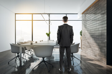 Young businessman standing in conference interior