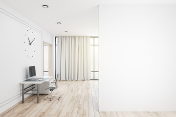 Minimalistic office interior with computers and large clock on wall.
