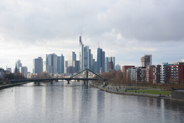 Fototapeta premium View on Frankfurts Skyline, seen from a bridge over the river Main