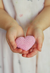 Fototapeta premium child's hands holding knitted heart