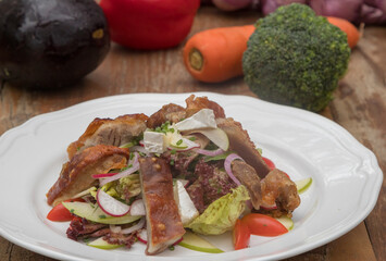 Mix leaves with pork roast slices, crackling, apple, Camembert cheese, cherry tomatoes, and apple vinaigrette