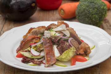 Mix leaves with pork roast slices, crackling, apple, Camembert cheese, cherry tomatoes, and apple vinaigrette