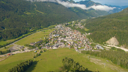Fototapeta na wymiar AERIAL: Idyllic town of Kranjska Gora is surrounded by lush mountain landscape.