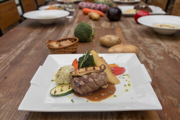 Chargrilled beef tenderloin with mixed vegetables, potato gratin mushroom sauce