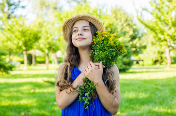 Little girl with freshly picked St. John's Wort bouquet