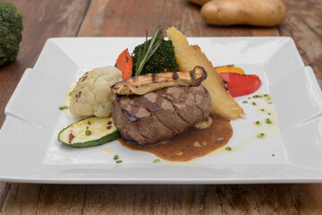 Chargrilled beef tenderloin with mixed vegetables, potato gratin mushroom sauce