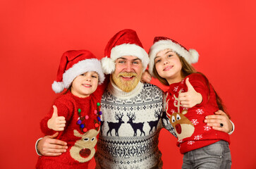 New Year together. knitted fashion for everyone. warm and cosy winter. new year is here. happy family celebrate xmas. small girls love their father. dad embrace daughters. bearded santa man with kids