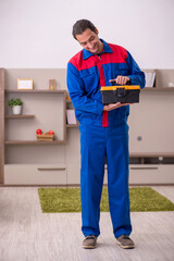 Young male contractor repairing furniture indoors