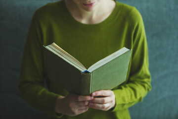 young woman reading book at home