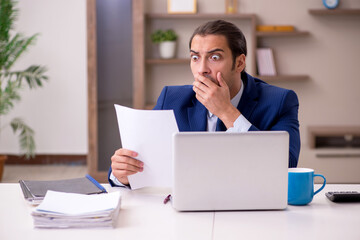 Young male employee working from home in pandemic concept