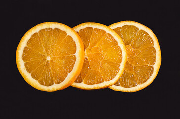 Three orange slices on black background