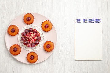 top view delicious cakes with grapes inside plate on a white background pie dessert cake