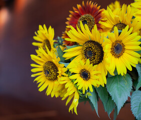 Bright yellow sunflowers in full bloom in a green ceramic vase