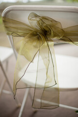 Chair decorated with green tulle ribbon