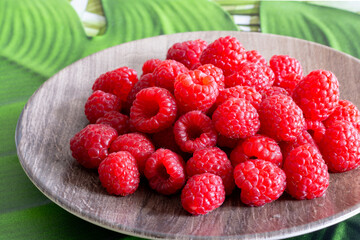 Framboises dans une assiette en bois