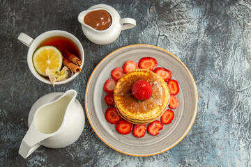 top view yummy pancakes with cup of tea and fruits on a light background fruit cake sweet