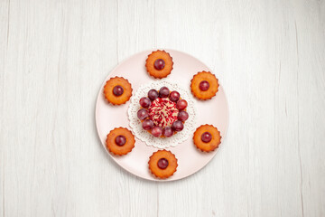 top view delicious cakes with grapes inside plate on a white background fruit dessert cake