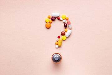 medicine pills question mark symbol isolated over pink background. medical decision concept