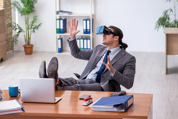 Young male employee wearing virtual glasses in the office