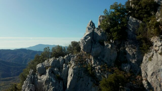 Aerial view over a rocky mountain, revealing a large flat valley, high altitude in Cilento and Vallo di Diano, Italy,  sunny day - rising, drone shot