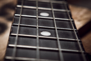 macro close-up of ukulele in brown details with dark background and backlight