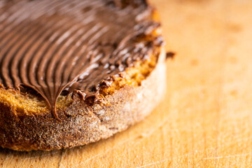 Slice of homemade bread with chocolate cream on the kitchen table for breakfast. Selective focus. Shallow depth of field.
