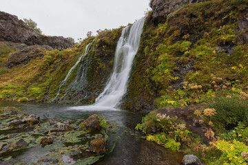 Naklejka na ściany i meble Gjain waterfall at small valley Gjain with its small waterfalls, ponds, and volcanic structures in the south of Iceland, about half an hour walking distance from the historical farm Stöng.