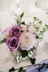 Composition of violet, white flowers and greenery on table. Home decor. Wedding decoration.