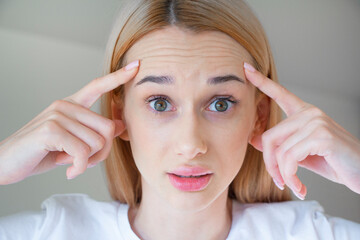 
A young girl has deep wrinkles on her forehead