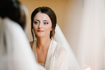 Naklejka premium Gorgeous beauty young portrait bride. Beautiful bride with wedding makeup. Bridal fashion model look in mirror.