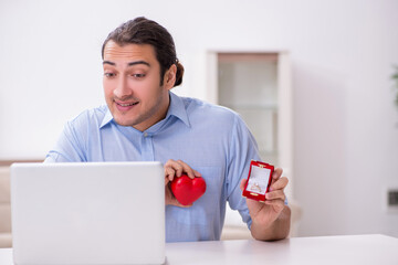 Young man doing marriage proposal via Internet